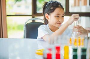 little scientist looking through a microscope and test tubes filled with chemicals for learning about science and experiments. photo