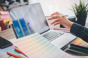 Graphic designer architects who work with laptops and color comparison tables for design work. photo