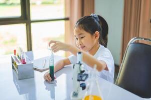 little scientist looking through a microscope and test tubes filled with chemicals for learning about science and experiments. photo