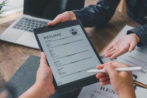 HR managers are interviewing job applicants who fill out their resume on the job application form in order to consider accepting a job as a company photo