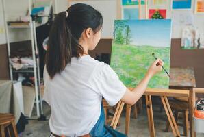 Art student drawing with watercolor painting on canvas doing some art projects on studio workshop photo