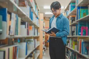 Students are reading and looking for books to study, make reports, find useful information on the bookshelves in the library. Concept of reading, learning and intelligence. photo