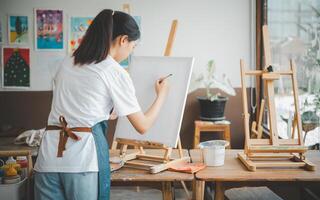 Art student drawing with watercolor painting on canvas doing some art projects on studio workshop photo