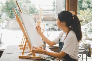 Art student drawing with watercolor painting on canvas doing some art projects on studio workshop photo