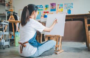 Art student drawing with watercolor painting on canvas doing some art projects on studio workshop photo