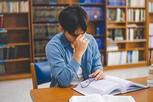 Students feel tired and stressed after working on their laptops and looking for books to study, make reports, find useful information in the university room. photo