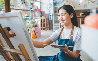 Art student drawing with watercolor painting on canvas doing some art projects on studio workshop photo