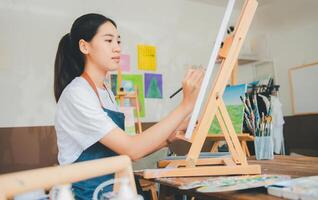 Art student drawing with watercolor painting on canvas doing some art projects on studio workshop photo