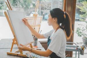 Art student drawing with watercolor painting on canvas doing some art projects on studio workshop photo