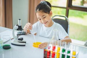 little scientist looking through a microscope and test tubes filled with chemicals for learning about science and experiments. photo