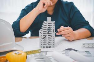 Engineer with collapsed building model, engineer analyzing Cause of building collapse or house collapse photo
