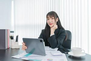 business woman working on the tablet ,discussing customer and checking business analytic document report working place in office. photo