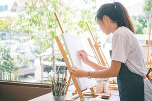 Art student drawing with watercolor painting on canvas doing some art projects on studio workshop photo