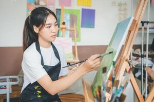 Art student drawing with watercolor painting on canvas doing some art projects on studio workshop photo