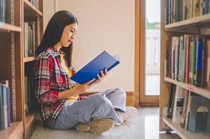 Students are reading and looking for books to study, make reports, find useful information on the bookshelves in the library. Concept of reading, learning and intelligence. photo