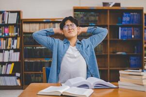 Students are relaxing after working on their laptops and searching for books to study, make reports, find useful information in the university room. photo