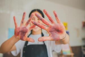 Close-up art student's hands stained after watercolor painting on canvas doing some art projects on studio workshop photo