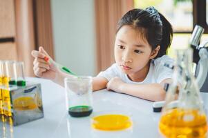 little scientist looking through a microscope and test tubes filled with chemicals for learning about science and experiments. photo
