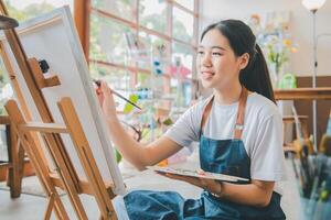 Art student drawing with watercolor painting on canvas doing some art projects on studio workshop photo