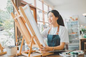 Art student drawing with watercolor painting on canvas doing some art projects on studio workshop photo