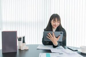 business woman working on the tablet ,discussing customer and checking business analytic document report working place in office. photo