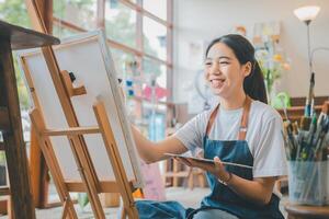 Art student drawing with watercolor painting on canvas doing some art projects on studio workshop photo