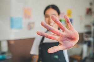 Close-up art student's hands stained after watercolor painting on canvas doing some art projects on studio workshop photo