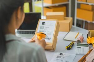 online small business owner scans a barcode-labeled parcel with a barcode scanner to verify a customer's order before it is delivered to the customer. photo