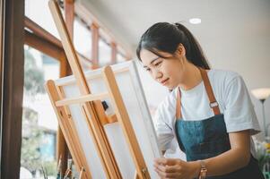 Art student drawing with watercolor painting on canvas doing some art projects on studio workshop photo