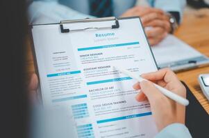 HR managers are interviewing job applicants who fill out their resume on the job application form in order to consider accepting a job as a company photo