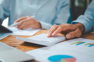 close up The business person is sitting on a calculator with a graph in the office of finance accounting concept photo