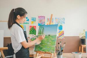 Art student drawing with watercolor painting on canvas doing some art projects on studio workshop photo