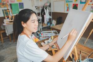 Art student drawing with watercolor painting on canvas doing some art projects on studio workshop photo