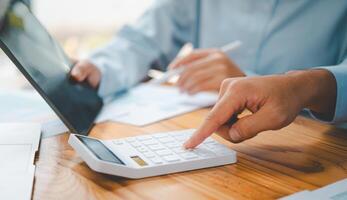close up The business person is sitting on a calculator with a graph in the office of finance accounting concept photo