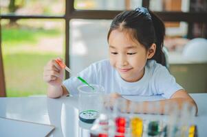 little scientist looking through a microscope and test tubes filled with chemicals for learning about science and experiments. photo