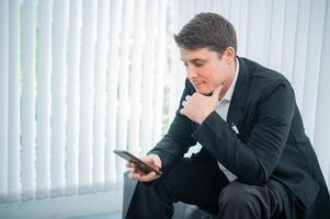 Businessman working on the phone touching the screen, browsing the internet or writing text messages. photo