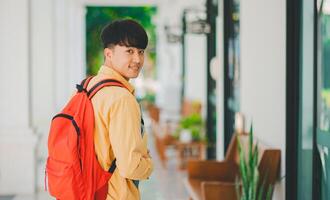 Happy smiling student with book in hand on campus while going to study for learning. photo