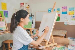 Art student drawing with watercolor painting on canvas doing some art projects on studio workshop photo