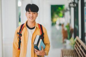 Happy smiling student with book in hand on campus while going to study for learning. photo