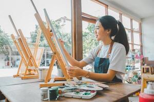 Art student drawing with watercolor painting on canvas doing some art projects on studio workshop photo