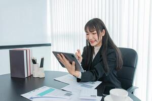 business woman working on the tablet ,discussing customer and checking business analytic document report working place in office. photo