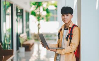 Happy smiling student with book in hand on campus while going to study for learning. photo