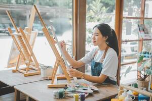 Art student drawing with watercolor painting on canvas doing some art projects on studio workshop photo