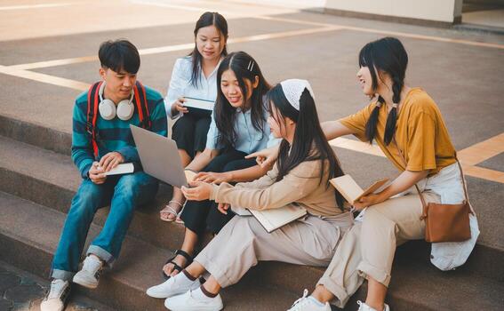 group of students young university students consulting doing homework, cooperating research plan Discuss concepts and strategies. Prepare presentations on laptops and tablet computers. photo