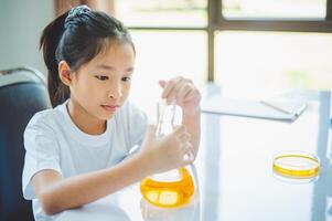 little scientist looking through a microscope and test tubes filled with chemicals for learning about science and experiments. photo