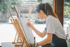 Art student drawing with watercolor painting on canvas doing some art projects on studio workshop photo