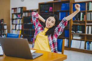 Students are relaxing after working on their laptops and searching for books to study, make reports, find useful information in the university room. photo