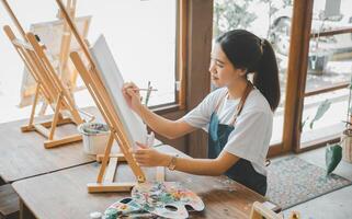 Art student drawing with watercolor painting on canvas doing some art projects on studio workshop photo