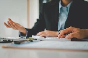close up The business person is sitting on a calculator with a graph in the office of finance accounting concept photo