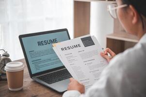 People are reviewing job applications before filling out their resume on the job application form in order to apply for a job at a company. photo